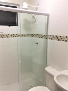 a bathroom with a glass shower with a toilet and a sink at Pedra do Imperador - Apartamento in Nova Friburgo +14 photos