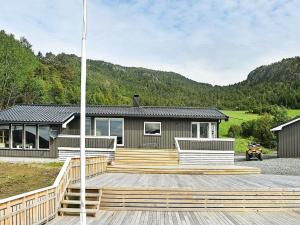 een huis met een houten terras en een huis bij 8 person holiday home in Sundlandet in Snildal