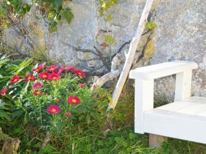 a white bench sitting next to a bunch of flowers at 11 person holiday home in Fj rtoft in Fjørtoft