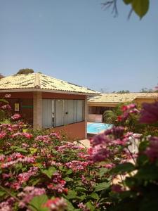 a house with pink flowers in front of it at Pousada Santa Helena in Iriri