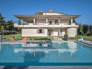 una casa con piscina frente a ella en Belvilla by OYO Il Panorama Trenta, en Tavullia