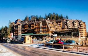 a large building with cars parked in front of it at LUX apartman B432 Aparthotel Vučko Jahorina - private host in Jahorina
