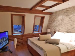 a bedroom with a bed and a desk with a television at LUX apartman B432 Aparthotel Vučko Jahorina - private host in Jahorina