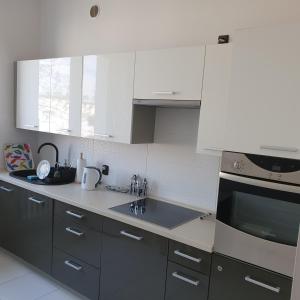 a kitchen with white cabinets and a stove top oven at GreyT in Toruń