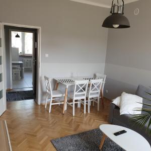 sala de estar con mesa, sillas y sofá en GreyT, en Toruń