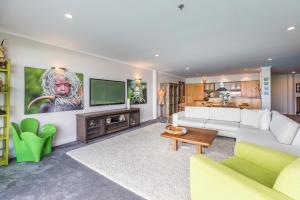 a living room with a couch and a tv at QV Waterfront Apt with AC Wifi and Parking (941) in Auckland