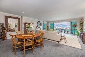 a living room with a table and chairs and a couch at QV Waterfront Apt with AC Wifi and Parking (941) in Auckland