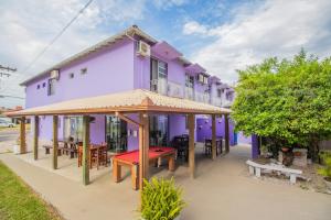 einem lila Gebäude mit Tischen und Stühlen davor in der Unterkunft Pousada Santa Ana in Florianópolis