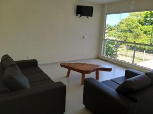 a living room with a couch and a table and a window at Propriedade patolo in São Miguel dos Milagres