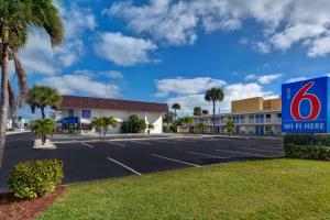 uma vista de um edifício wii aqui com um parque de estacionamento em Motel 6-Cocoa Beach, FL em Cocoa Beach