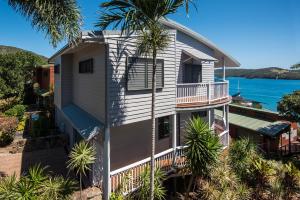 an image of a house with a palm tree at Casuarina Cove 13 on Hamilton Island by HamoRent in Hamilton Island