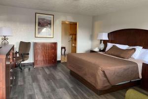 Habitación de hotel con cama y escritorio en Travelodge by Wyndham Farmington Hwy 64, en Farmington