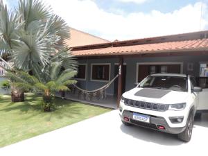 a white jeep parked in front of a house at Casa Parque e Kartódromo in Penha