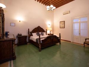 a bedroom with a bed and a table and a window at Hotel Senorial in Querétaro