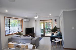 uma sala de estar com um sofá e uma televisão em BILL'S em Coffs Harbour