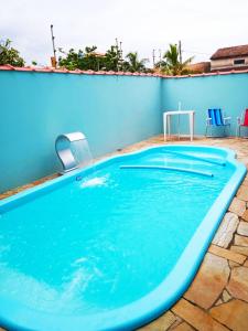 a swimming pool with a blue wall at Casa com piscina à beira-mar in Itanhaém