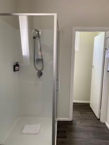 a bathroom with a shower with a glass door at Alpers Lodge & Conference Centre in Auckland