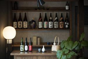un montón de botellas de vino sentadas en un estante en Saitosyukuba, en Sonogi