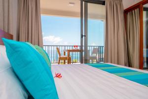 a bedroom with a bed and a balcony at Kolibri Holiday Apartments in Victoria
