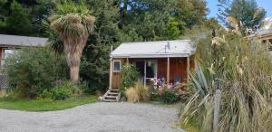 a small house with a palm tree in front of it at Lake Tekapo Cottages in Lake Tekapo
