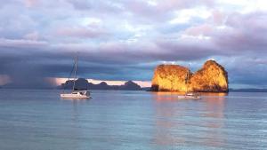 two boats in the water near a small island at Thanya Beach Resort - SHA Plus in Ko Ngai