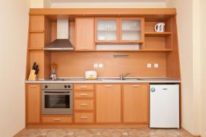 a kitchen with wooden cabinets and a white refrigerator at Apartments in Central Plaza in Sunny Beach