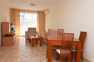 sala de estar con mesa, sillas y TV en Apartments in Central Plaza, en Sunny Beach