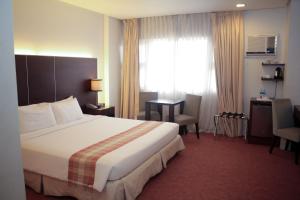 a hotel room with a bed and a desk and a window at Casablanca Suites Near Airport in Legazpi +84 photos