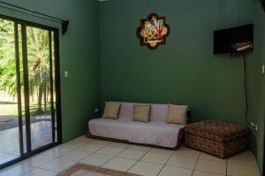 ココにあるLas QuiNtas Casas para VacacionaRの緑の壁、ベッド付きのベッドルーム1室