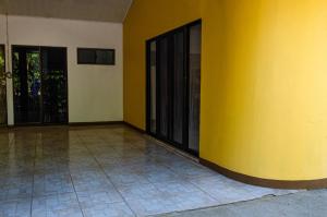 eine gelbe Wand in einem Zimmer mit Fliesenboden in der Unterkunft Las QuiNtas Casas para VacacionaR in Coco