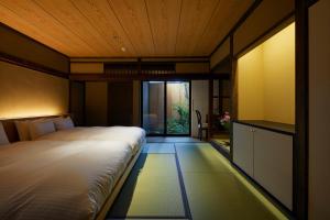 a bedroom with a bed and a large window at UNO RETREAT Kyoto Gluten Free & Vegan Hotel in Kyoto
