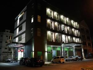 un edificio con coches aparcados delante de él por la noche en Nova Kuching Hotel, en Kuching