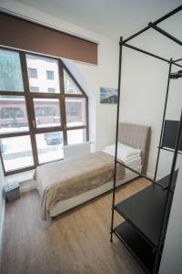 a bedroom with a bed and two windows at Sulu Hostel in Astana