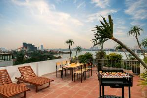 a patio with a table and chairs on a roof at Pegasy Suites Lakeside in Hanoi