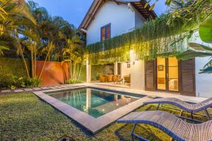 a villa with a swimming pool and two chairs at Rumi Villas in Seminyak