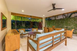 a patio with a table and chairs and a ceiling fan at Rumi Villas in Seminyak