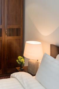 a bedroom with a bed and a table with a lamp at Pegasy Suites Lakeside in Hanoi