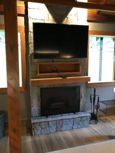 a living room with a fireplace with a flat screen tv at Chalé Realli in Visconde De Maua