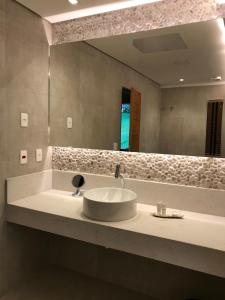 a bathroom with a sink and a large mirror at Chalé Realli in Visconde De Maua +95 photos