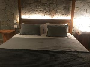 um quarto com uma cama grande e uma parede de pedra em Chalé Realli em Visconde de Mauá