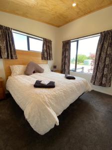 a bedroom with a bed with two towels on it at Country Retreats on Ranzau 1 in Nelson
