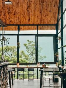 a dining room with a table and chairs and windows at Le vent Tam Đảo homestay in Tam Ðảo
