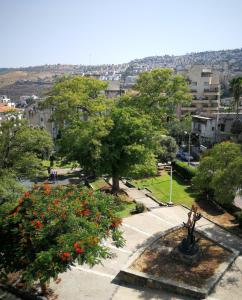 un parc avec des arbres et des fleurs dans une ville dans l'établissement Astoria Galilee Hotel, à Tibériade