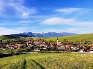 a small town in a field with mountains in the background at Privat Mima in Liptovský Trnovec