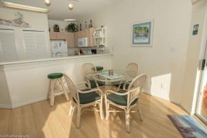 una sala da pranzo con tavolo in vetro e sedie di Sandpiper Cove #9226 Condo a Destin