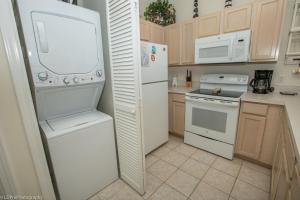 una cucina con elettrodomestici bianchi e frigorifero bianco di Sandpiper Cove #9226 Condo a Destin