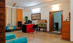 a living room with a desk and a table with chairs at Treebo Umal Homestay Ganeshguri in Guwahati