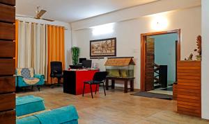 a living room with a desk and a table with chairs at Treebo Trend Umal Homestay Ganeshguri in Guwahati