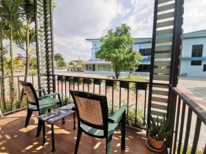 Un balcón con sillas y mesas y vistas al océano. en Menam Resort, en Nakhon Pathom