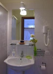 W łazience znajduje się umywalka i lustro. w obiekcie Aenea's B&B w Rzymie